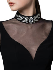 A high-neck gown featuring a crystal-embellished collar and cascading chiffon sleeves with chiffon godets that create a flowing movement.
