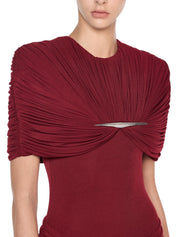 Form-fitting long dress featuring symmetrical draping at the bust and hips accented with a refined metal accessory
